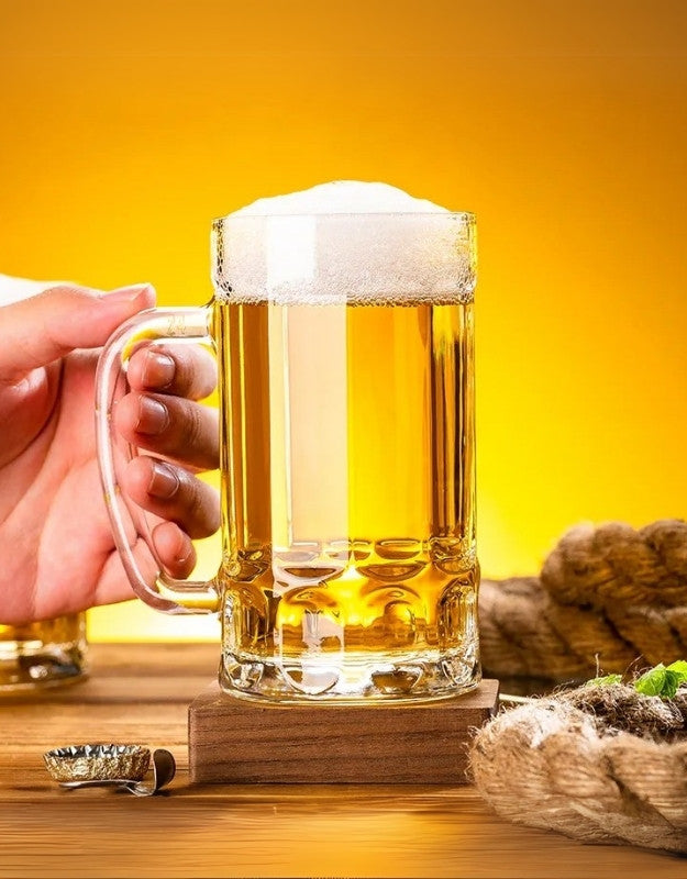 Hand holding a glass of beer with a yellow background.